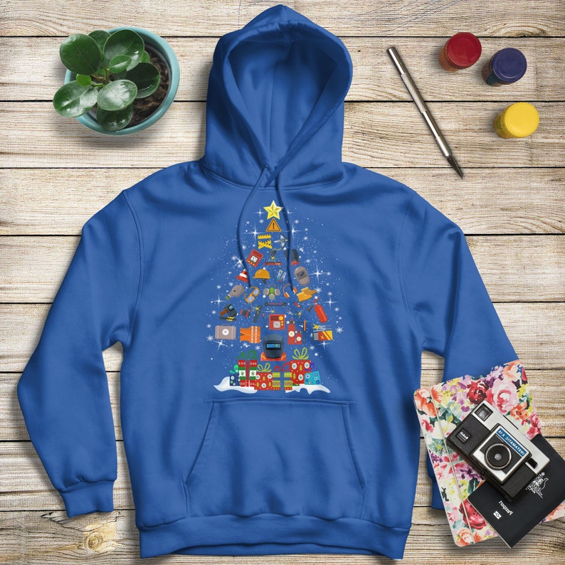 May include: A royal blue hoodie with a Christmas tree design featuring various tools and equipment. The tree is decorated with a star on top and presents at the bottom.
