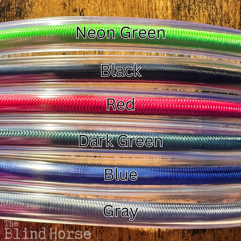 May include: A collection of six flexible, clear plastic tubes, each containing a different colored cord: neon green, black, red, dark green, blue, and gray. The text labels for each color are printed over the corresponding tube.