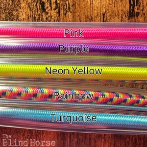 May include: Five parallel clear plastic tubes containing braided cords in pink, purple, neon yellow, rainbow, and turquoise colors. Each cord is labeled with its corresponding color name in white text. The brand name The Blind Horse is visible.