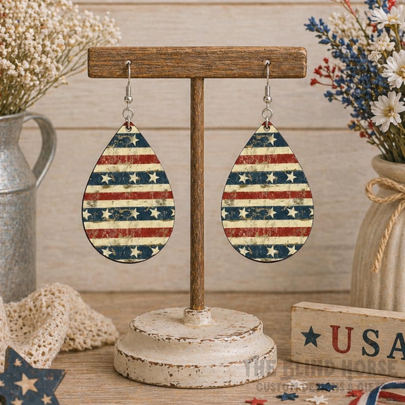 Puede incluir: Pendientes en forma de l&aacute;grima con un dise&ntilde;o de bandera americana desgastada. Presentan rayas rojas y blancas y estrellas azules. Un accesorio de estilo vintage, ideal para celebraciones patri&oacute;ticas o uso diario.