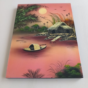 May include: A rectangular painting depicting a serene waterscape with a boat, a hut, and palm trees under a full moon. The artwork features a color palette of pink, green, and yellow, creating a tranquil scene.