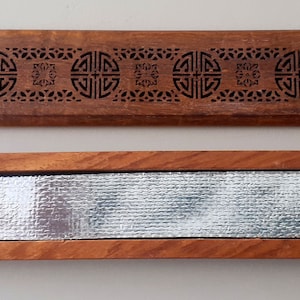 May include: A wooden incense holder with a decorative carved design and a removable metal insert. The holder is closed and the metal insert is visible.