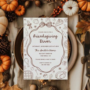 Op de afbeelding: Een Friendsgiving Dinner-uitnodiging met een bruine rand en illustraties van voedsel en herfstelementen. De uitnodiging bevat de tekst "Friendsgiving Dinner" en details voor het evenement, inclusief datum, tijd en locatie.