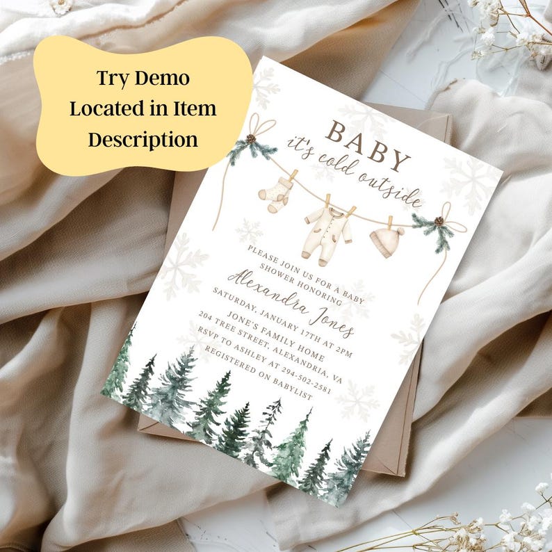 May include: A baby shower invitation with the text "BABY it's cold outside." The invitation features illustrations of baby clothes hanging on a clothesline, snowflakes, and a watercolor forest. The text "Try Demo Located in Item Description" is also present.