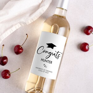 May include: A white wine bottle with a black and white graduation label. The label says "Congrats Hunter University of Toronto Class of 2022".