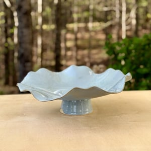 May include: A rustic wooden sign with the text "Welcome to our home" in white lettering. The sign features a distressed finish and a simple, inviting design, perfect for front door decor.