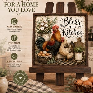 May include: A square wooden sign featuring a rooster and hen, a basket of eggs, and a pitcher of cotton stems. The text reads Bless THIS Kitchen. The sign is displayed on a wooden easel, with a small basket of brown eggs placed in the foreground.