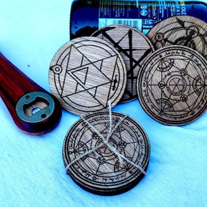 May include: Set of four wooden coasters featuring intricate black and white circular designs. The coasters are tied together with twine.