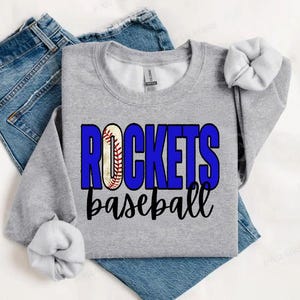 May include: Gray sweatshirt with a blue and white baseball graphic and the text "ROCKETS baseball" printed on the front.