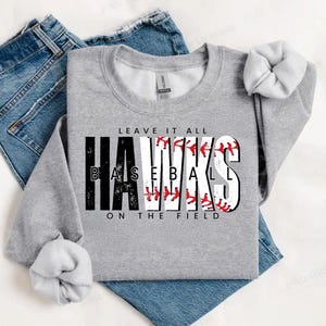 May include: Gray sweatshirt with the text "Leave it all HAWKS BASEBALL ON THE FIELD" in black and white with a baseball graphic.