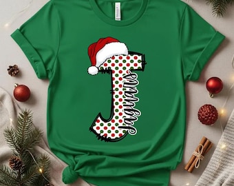 May include: Green t-shirt featuring a large letter "J" decorated with red and green polka dots, and a Santa hat. The word "Jaguars" is written vertically on the letter. A festive holiday design.