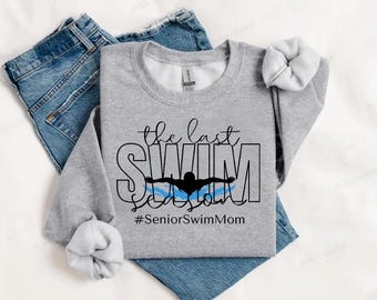 Può includere: Felpa grigia con il testo "the last swim season" e una silhouette di un nuotatore. Il testo "#SeniorSwimMom" è sotto il nuotatore.