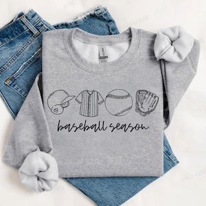 May include: Grey sweatshirt with a black baseball themed graphic that says "baseball season". The graphic includes a baseball, bat, glove, and baseball jersey.