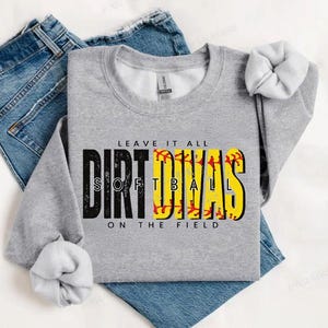 May include: Gray sweatshirt with the text "Leave it all Dirt Divas Softball on the field" in black and red. The text is surrounded by yellow softball graphics.