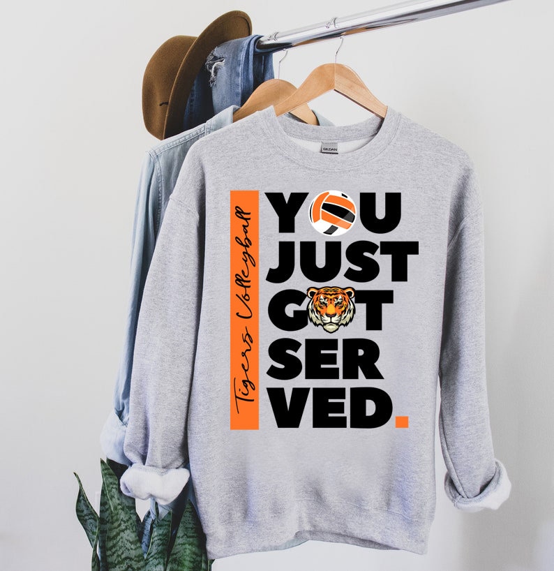 Puede incluir: Sudadera gris con un gr&aacute;fico negro y naranja que dice "You Just Got Served." El gr&aacute;fico tambi&eacute;n incluye un bal&oacute;n de voleibol y una cabeza de tigre. El texto "Tigers Volleyball" est&aacute; en el lado del gr&aacute;fico.