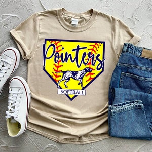 May include: Tan t-shirt with a yellow softball graphic and the text "Pointers Softball". The graphic features a red and blue baseball diamond with a white dog inside.