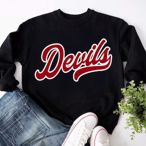 May include: Black sweatshirt with a red "Devils" graphic in a vintage style font.