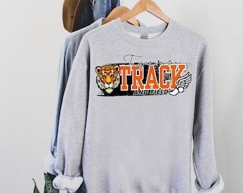 May include: Gray sweatshirt with a black and orange graphic of a tiger head, the words "Tigers Track and Field", and a winged running shoe.