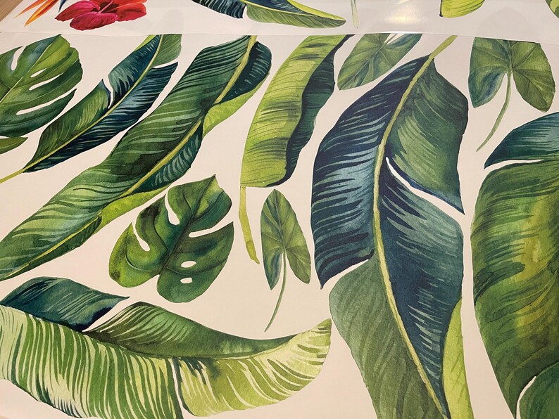 May include: A white background with a pattern of green and blue tropical leaves. The leaves are painted in a watercolor style and have a realistic look.