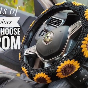 May include: A black crochet steering wheel cover with yellow and brown sunflower designs. The text "Lots of colors TO CHOOSE FROM" is displayed in white. The cover is on a black steering wheel.