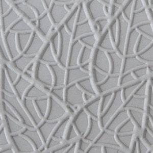 Op de afbeelding: Een witte textuur achtergrond met een patroon van overlappende lijnen en curves.