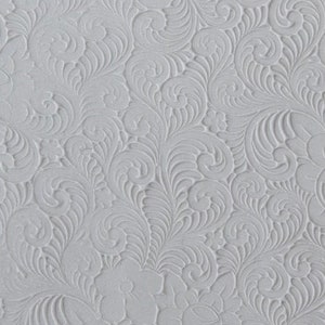 May include: A white textured background with a repeating pattern of embossed swirls and floral designs.