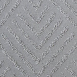 Può includere: Primo piano di una superficie bianca testurizzata con un motivo a chevron ripetuto.