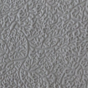 May include: A close-up of a gray textured surface with a repeating pattern of small, raised leaves. The surface has a subtle sheen.