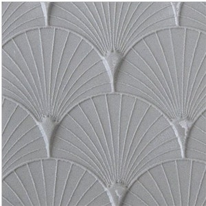 Puede incluir: Primer plano de una superficie gris texturizada con un patrón repetitivo de formas de abanico en relieve.