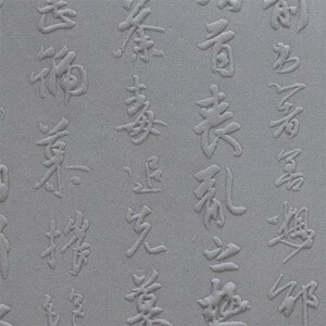May include: A close-up of a gray textured surface with embossed Chinese characters. The characters are arranged in vertical columns and are repeated throughout the surface.