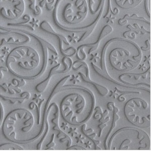May include: A close-up of a gray textured silicone mold with a repeating pattern of swirls and stars. The mold is designed for creating decorative cake toppers or other edible creations.