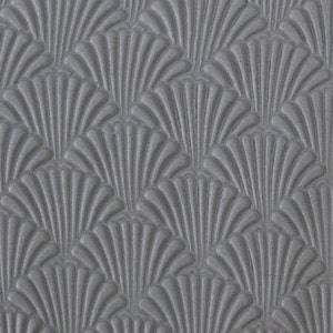 Puede incluir: Primer plano de una superficie gris texturizada con un patrón repetitivo en forma de abanico. El patrón está en relieve, creando un efecto tridimensional. El diseño recuerda al estilo Art Déco.