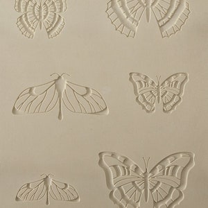 May include: A sheet of silicone with five butterfly designs embossed into the surface. The butterflies are in various sizes and styles.