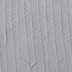 May include: Close-up of a textured, light gray surface with a repeating pattern of vertical, leaf-like shapes. The design has a subtle, raised relief, creating shadows and depth. The overall effect is a soft, organic texture.