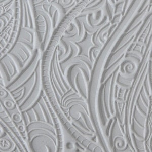 May include: A white silicone mold with a detailed, intricate design of swirling, abstract patterns. The mold is textured and appears to be flexible.