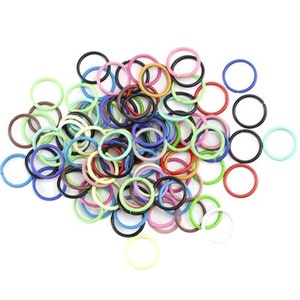 May include: A large pile of colourful metal jump rings. The rings are various sizes and are in a variety of colours, including red, blue, green, yellow, and purple.