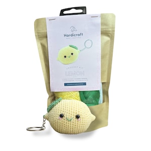 May include: A crochet kit for making a lemon-shaped keychain. The kit includes yellow and green yarn, a crochet hook, and instructions. The finished keychain features a cute, smiling lemon with a green leaf.