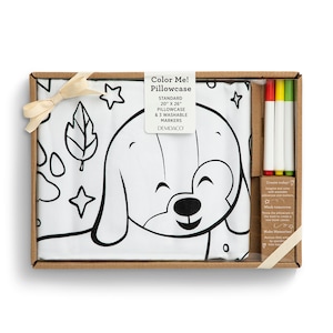 May include: A white standard size pillowcase with a black and white outline of a dog with stars and leaves. The pillowcase comes with three washable markers in a brown box. The box has the text "Color Me! Pillowcase Standard 20" x 26" Pillowcase & 3 Washable Markers DEMDACO" on it.