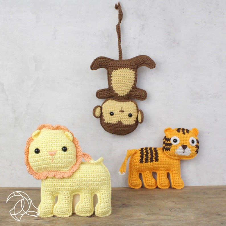 May include: Crocheted animal toys including a yellow lion with a peach mane, an orange tiger with black stripes, and a brown monkey hanging upside down. The toys are handmade and suitable for children.