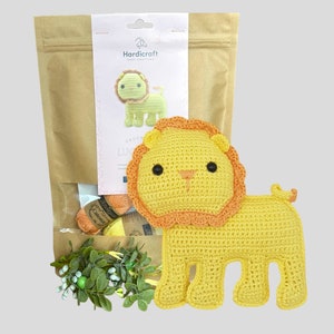May include: A yellow crochet lion with an orange mane and tail, next to a craft kit bag. The kit includes yarn and a printed label with a lion illustration and the text "Hardicraft". The lion is approximately 6 inches tall.