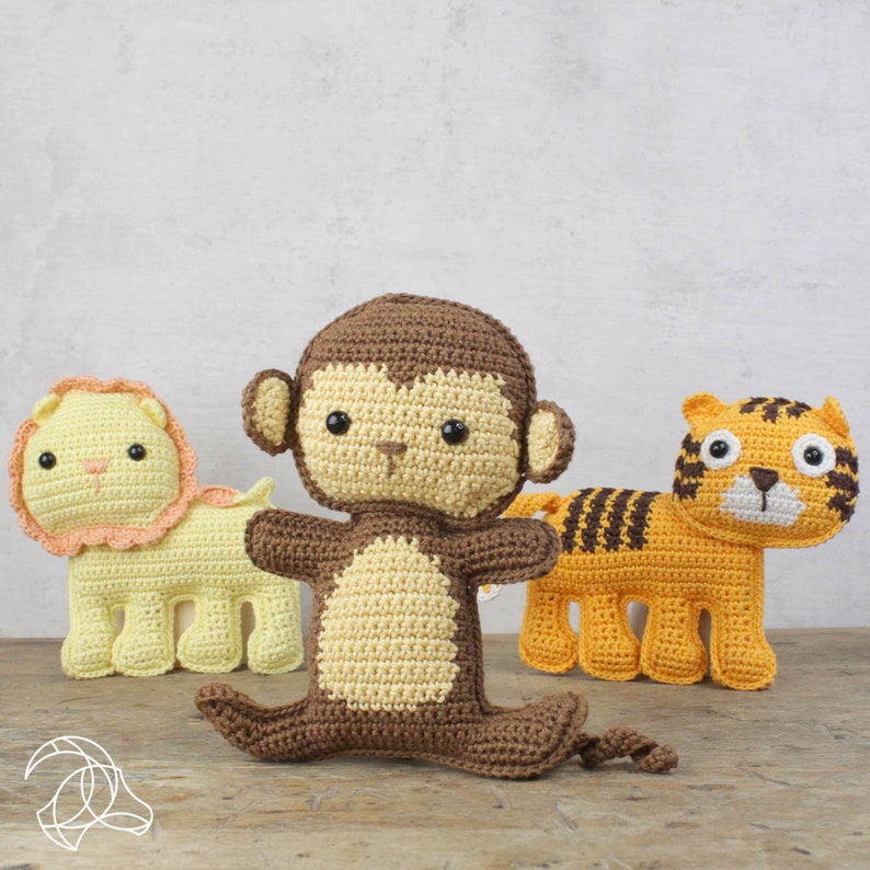 May include: Three crocheted animal toys: a yellow lion with a peach mane, a brown and tan monkey, and an orange tiger with black stripes. The toys are handmade and have black button eyes.