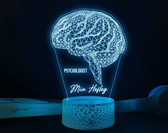 Puede incluir: Una luz nocturna de forma de cerebro azul impresa en 3D con el texto "Psicóloga Mia Hefley" en la base.