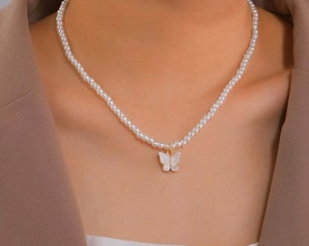 May include: A delicate pearl necklace with a small white butterfly pendant. The necklace is made of small, white pearls and has a simple, elegant design.