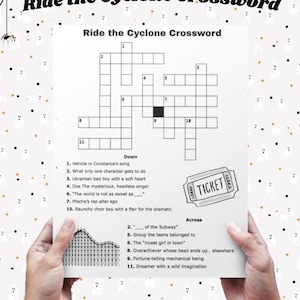 以下が含まれることがあります： 「Ride the Cyclone Crossword」というタイトルのクロスワードパズル。手がパズルを持っています。左下にはジェットコースターのグラフィック、右側にはチケットのグラフィックがあります。