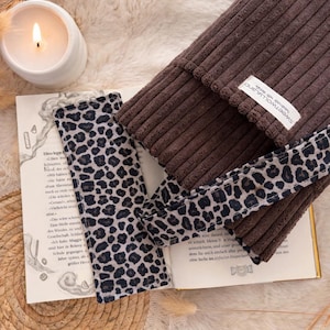 Weich gepolsterte braun Booksleeve mit leoprint Schleifenverschluss – einzigartiges Design für Leseratten und Geschenkidee Romantische Buchhülle im Vintage-Look – handmade aus Cordstoff mit zarter Schleife, perfekt für Bücher oder Journals.