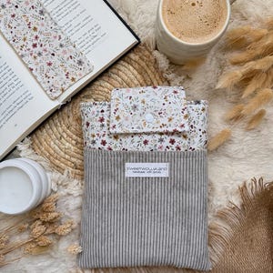 Weicher grauer Cord kombiniert mit romantischem Blumenstoff macht diese handgefertigte Buchhülle zu einem besonderen Leseaccessoire.