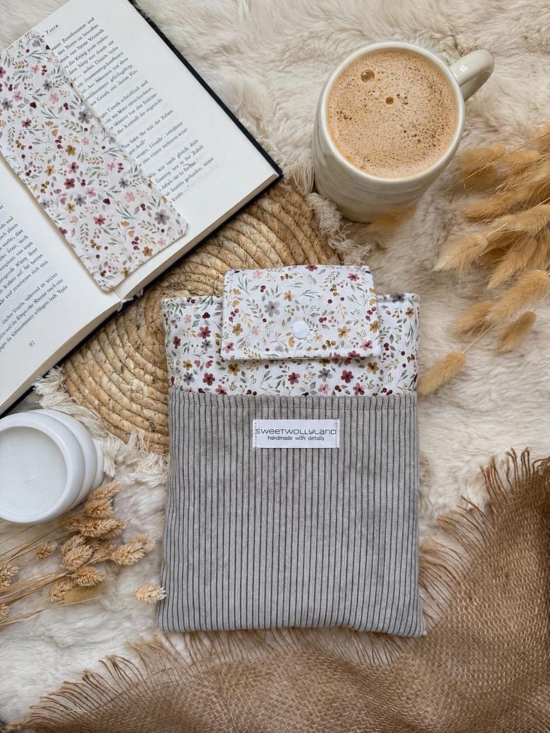 Weicher grauer Cord kombiniert mit romantischem Blumenstoff macht diese handgefertigte Buchhülle zu einem besonderen Leseaccessoire.