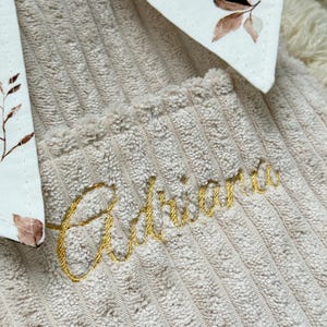 Personalisierte handgemachte Buchhülle aus hochwertigem beigem Breitcord mit eleganter goldener Namensstickerei und romantischem Kirschblüten Innenstoff, weich gefüttert zum stilvollen Schutz von Büchern, Hardcovern und Taschenbüchern im cozy Cottagecore Look