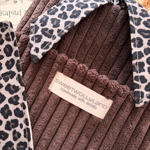Weich gepolsterte braun Booksleeve mit leoprint Schleifenverschluss – einzigartiges Design für Leseratten und Geschenkidee Romantische Buchhülle im Vintage-Look – handmade aus Cordstoff mit zarter Schleife, perfekt für Bücher oder Journals.
