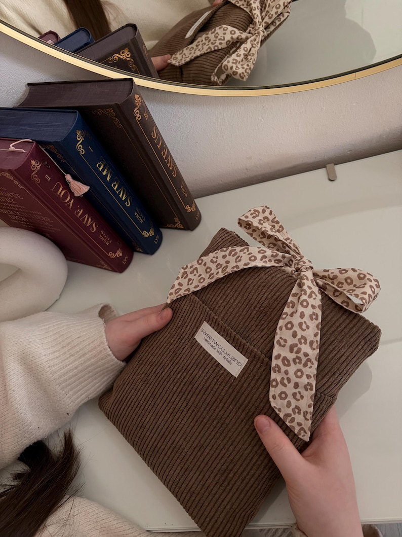 Weich gepolsterte braun Booksleeve mit leoprint Schleifenverschluss – einzigartiges Design für Leseratten und Geschenkidee Romantische Buchhülle im Vintage-Look – handmade aus Cordstoff mit zarter Schleife, perfekt für Bücher oder Journals.